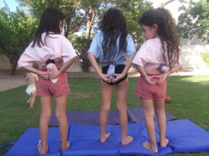 Heart Hands upside down on back of three girls